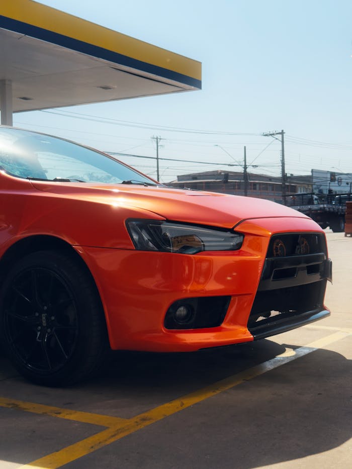 A striking red car parked at a sunny Brazilian gas station in São Paulo, Brazil.